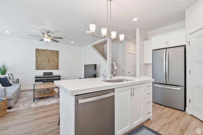 Kitchen with stainless steel appliances, open floor plan, light countertops, light wood-type flooring, and recessed lighting | Image 9