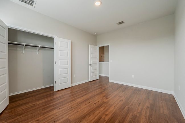Unfurnished bedroom with baseboards, visible vents, and dark wood-type flooring | Image 26