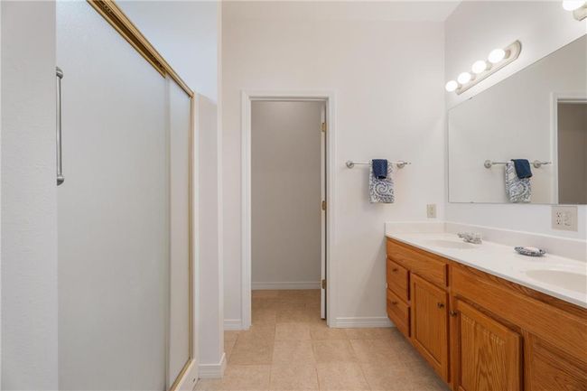 Full bath with a shower with shower door, tile patterned floors, and a sink | Image 21