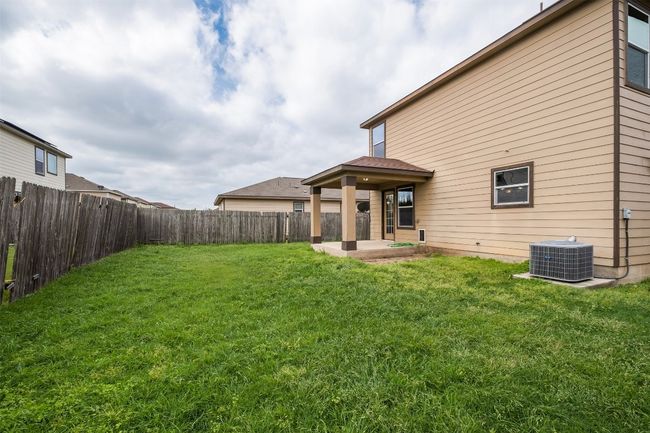 Back of house featuring a yard, central air condition unit, a fenced backyard, and a patio | Image 37