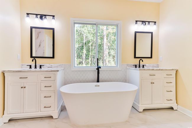 Bathroom featuring vanity, tile walls, and a washtub | Image 10