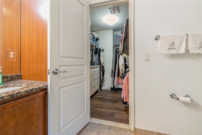 Bathroom with a walk in closet, vanity, tile patterned flooring, and visible vents | Image 12