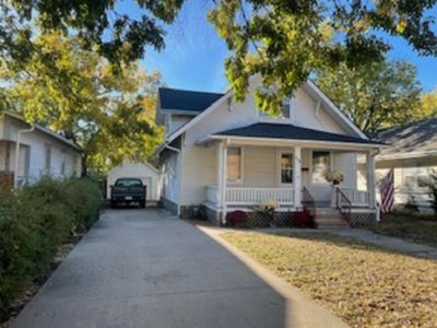 Bungalow-style house with a porch and a garage | Image 1