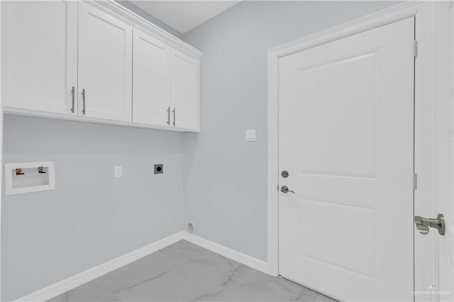 Clothes washing area featuring baseboards, washer hookup, cabinet space, electric dryer hookup, and marble finish floor | Image 17