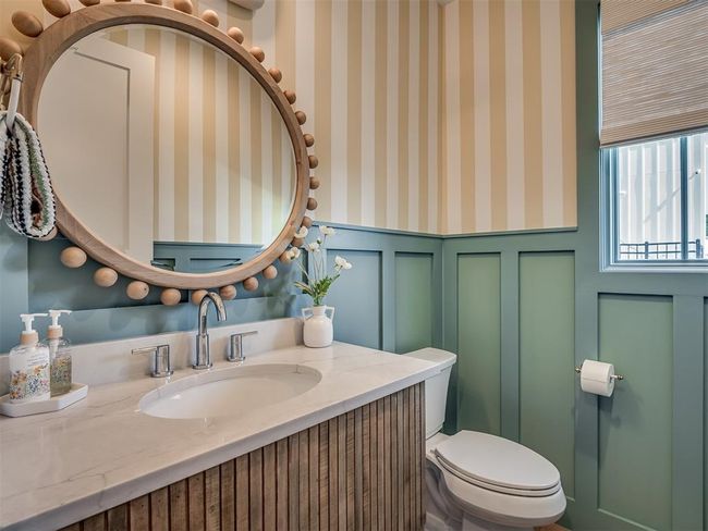 Half bath with wainscoting, toilet, a decorative wall, vanity, and wallpapered walls | Image 17