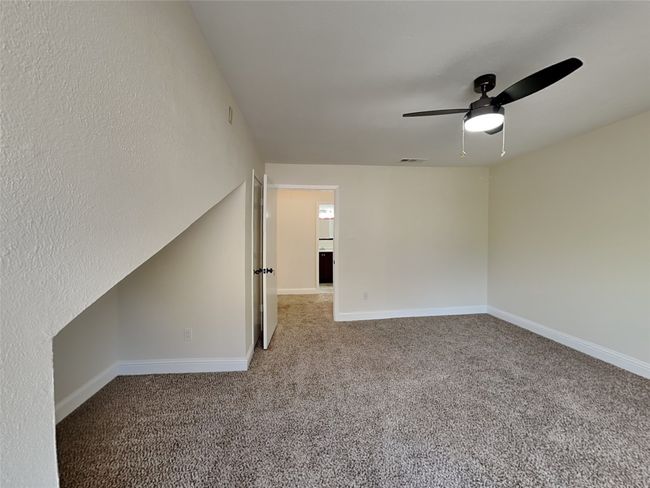 Empty room featuring baseboards, visible vents, carpet, and ceiling fan | Image 13