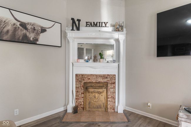 living room featuring baseboards, wood finished floors, and a fireplace with flush hearth | Image 6