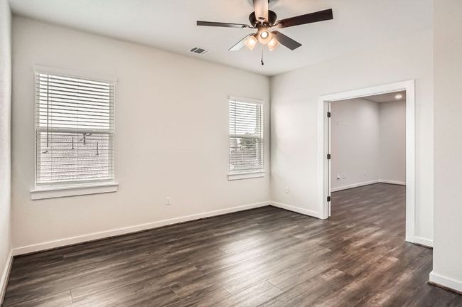 Empty room featuring a ceiling fan, dark wood-type flooring, and baseboards | Image 24