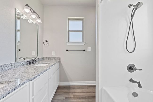 Bathroom featuring double vanity, shower / tub combination, and wood finished floors | Image 21