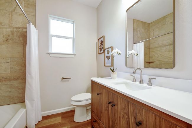 Bathroom featuring vanity, wood finished floors, and shower / tub combo with curtain | Image 21