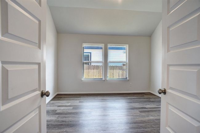 Spare room with baseboards, lofted ceiling, and wood finished floors | Image 17