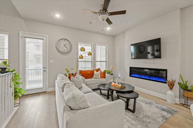 Living room with ceiling fan, light wood-style flooring, a glass covered fireplace, and recessed lighting | Image 5