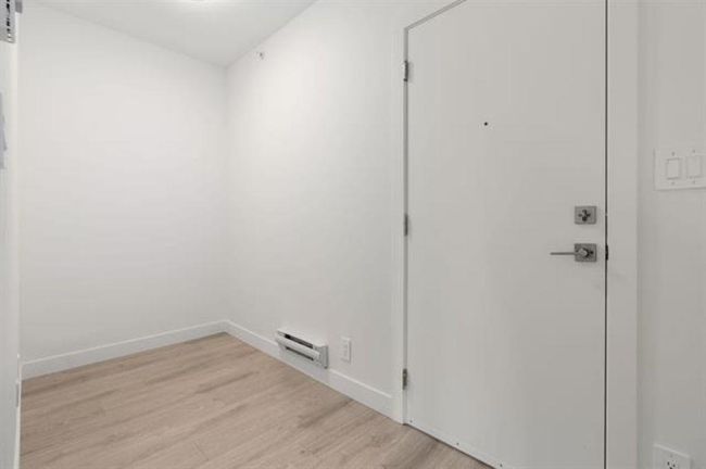 Interior space with laundry area, a barn door, light wood-style floors, and baseboards | Image 14