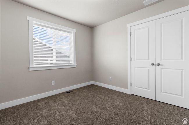 Unfurnished bedroom featuring dark colored carpet, baseboards, and a closet | Image 29
