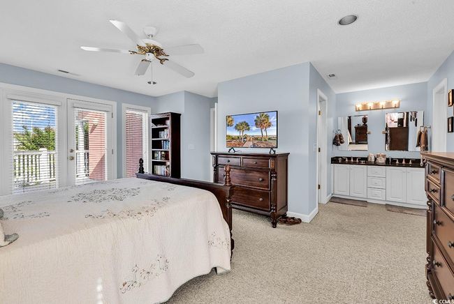 Bedroom with visible vents, baseboards, access to outside, light colored carpet, and ceiling fan | Image 20
