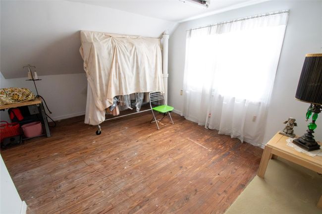 Bedroom featuring baseboards, lofted ceiling, and hardwood / wood-style floors | Image 21