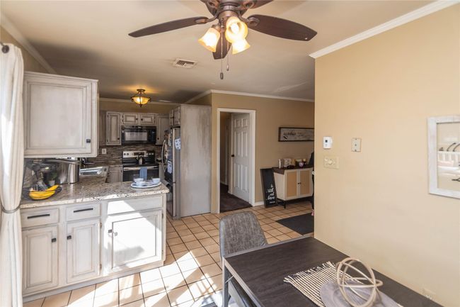 Kitchen featuring stainless steel appliances, visible vents, crown molding, tasteful backsplash, and ceiling fan | Image 9