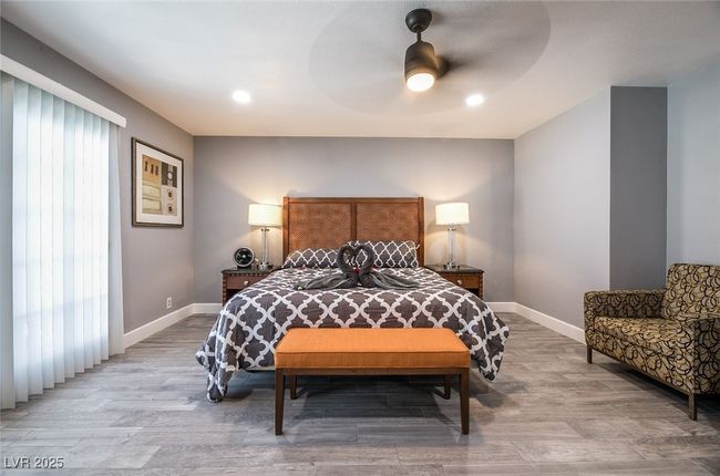 Bedroom featuring light wood-type flooring, baseboards, a ceiling fan, and recessed lighting | Image 36