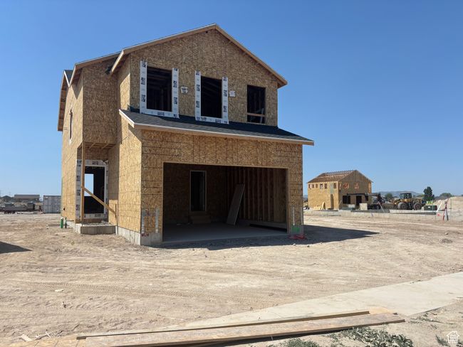 View of front of property with dirt driveway and an attached garage | Image 7