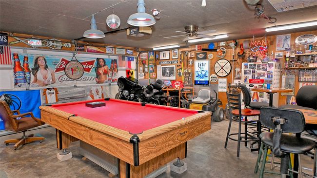 Recreation room with unfinished concrete floors, a ceiling fan, and pool table | Image 19