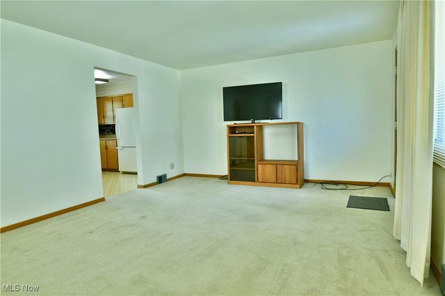 Unfurnished living room with visible vents, baseboards, and light carpet | Image 11