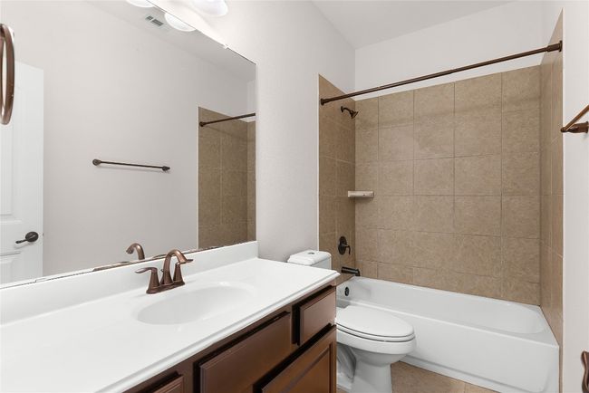 Bathroom with vanity, toilet, visible vents, and shower / bathtub combination | Image 16