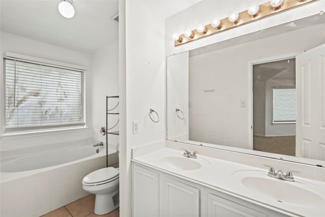 Bathroom featuring tile patterned flooring, toilet, a bath, and a sink | Image 14
