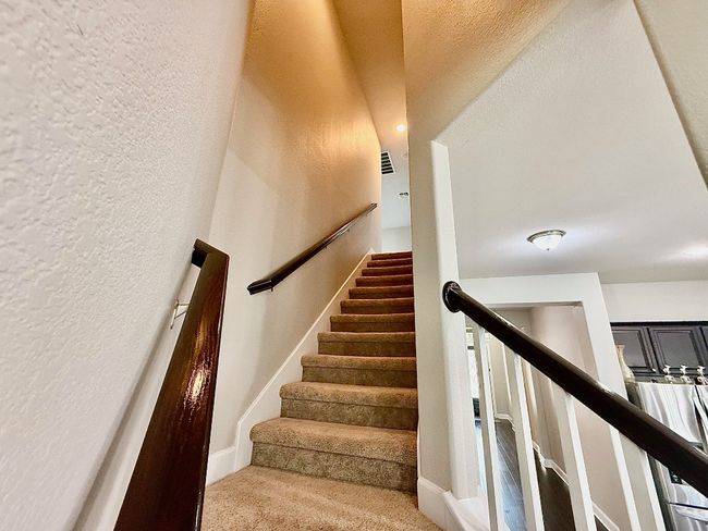 Stairs featuring carpet floors and a textured wall | Image 26