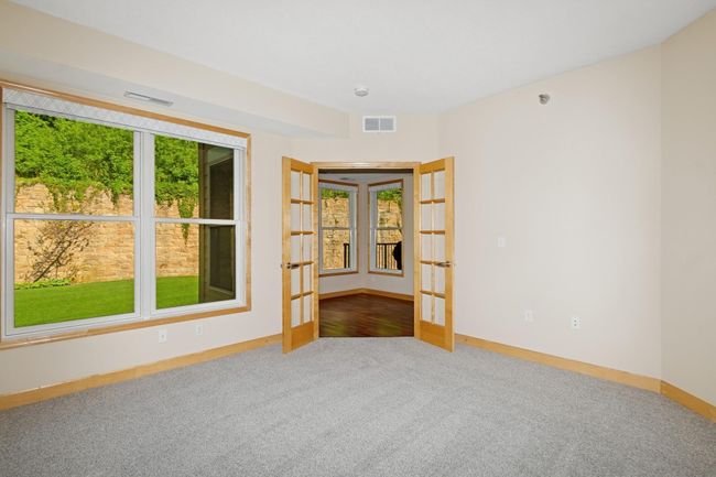 The guest bedroom faces west, overlooking peaceful green space for added privacy. It also has a walk-in closet and a convenient walk-through bathroom, perfect for guests or flexible everyday use . | Image 9