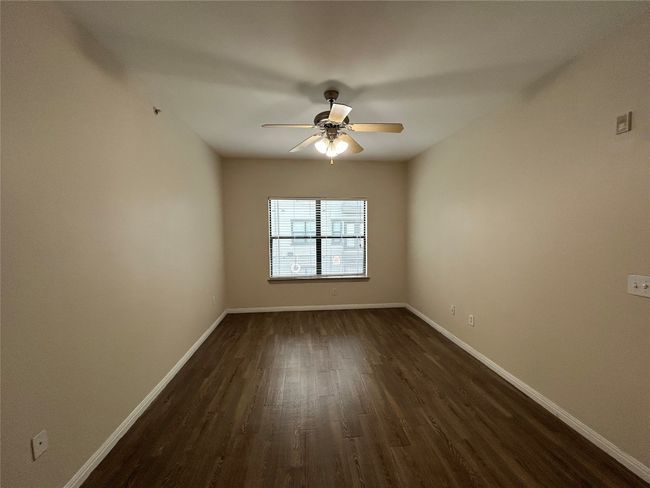 Spare room with dark wood-type flooring, baseboards, and a ceiling fan | Image 14
