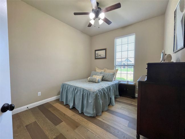 Bedroom with light wood finished floors, baseboards, and a ceiling fan | Image 29