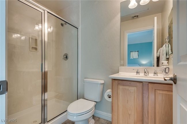 Full bath featuring toilet, vanity, a stall shower, and visible vents | Image 62