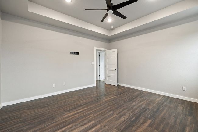 Primary bedroom with a tray ceiling, ceiling fan | Image 31