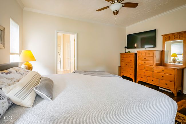 bedroom featuring ornamental molding, wood finished floors, and ceiling fan | Image 16
