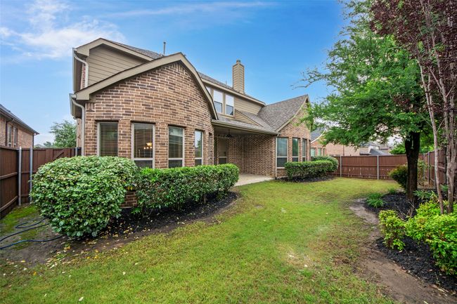 Back of house featuring a lawn, brick siding, a chimney, and a fenced backyard | Image 35