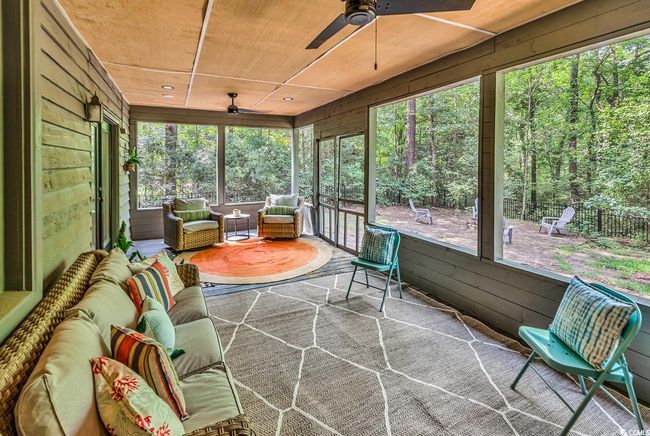 Sunroom / solarium with ceiling fan, an outdoor living space, and a wooded view | Image 28