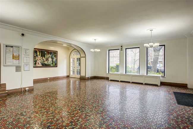 Unfurnished living room featuring baseboards, arched walkways, ornamental molding, and a chandelier | Image 15