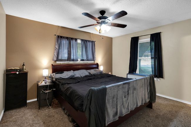 Carpeted bedroom with a textured ceiling and a ceiling fan | Image 10