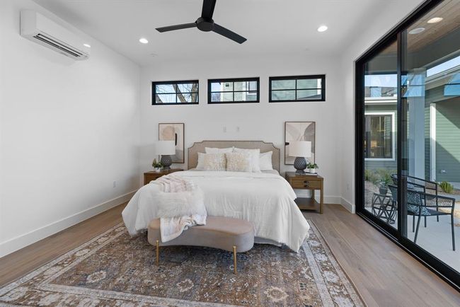 Bedroom with a wall unit AC, wood finished floors, baseboards, multiple windows, and recessed lighting | Image 40