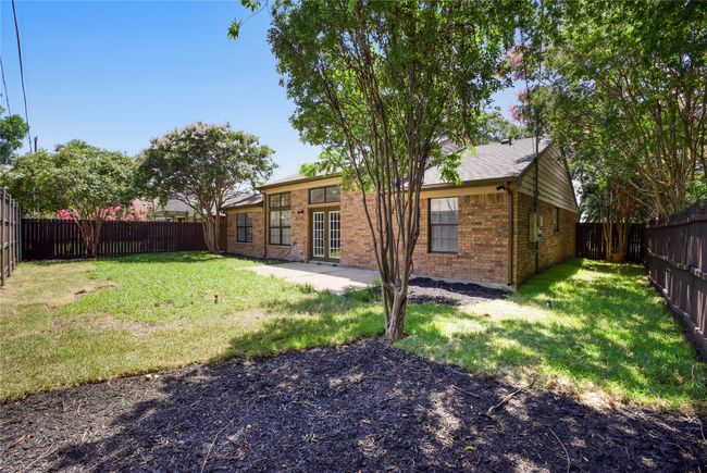 Rear view of house featuring brick siding, a fenced backyard, and a patio | Image 23