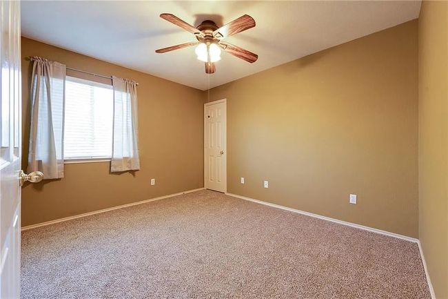 Carpeted empty room with a ceiling fan and baseboards | Image 13
