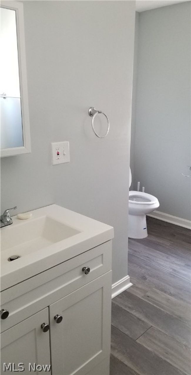 Bathroom with wood-type flooring, vanity, and toilet | Image 5