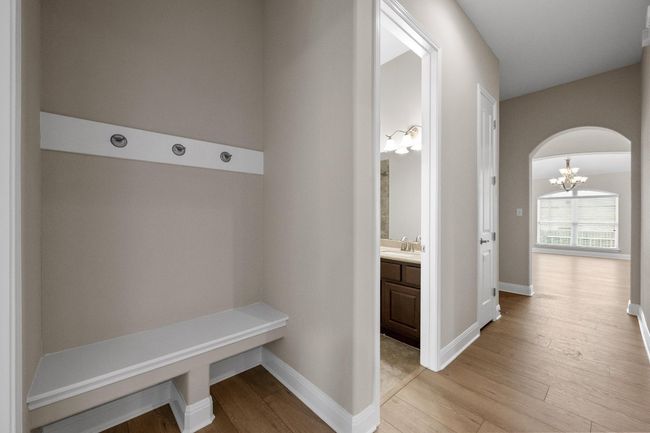 Mudroom with a chandelier, light wood-style floors, and arched walkways | Image 22