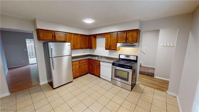 Kitchen featuring light hardwood / wood-style flooring, backsplash, appliances with stainless steel finishes, and sink | Image 3