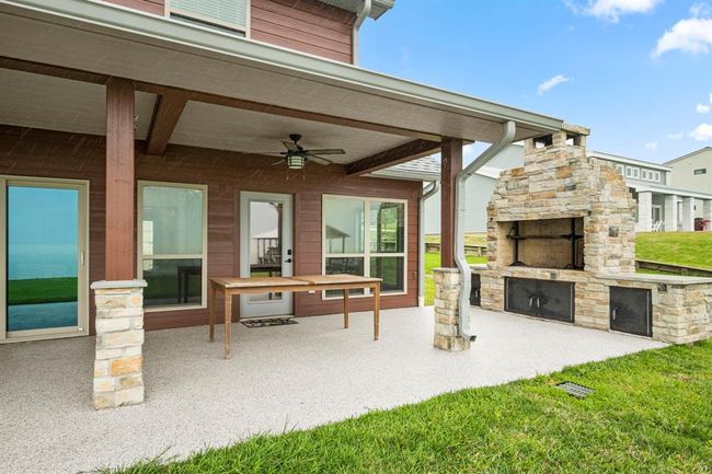 This over-sized covered patio sprawls throughout the back side of the home w/ massive outdoor oven made of stone. | Image 22