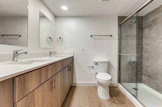 Bathroom with a shower with shower door, wood-type flooring, toilet, and vanity | Image 40