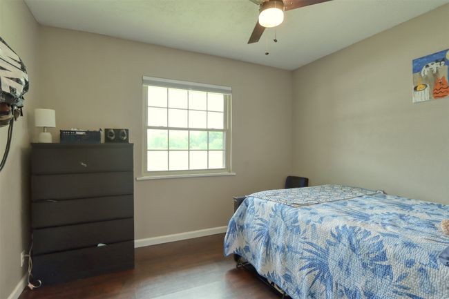 Bedroom with dark wood-style floors and a ceiling fan | Image 31