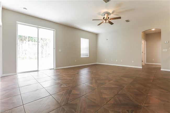 Empty room featuring arched walkways and a ceiling fan | Image 6