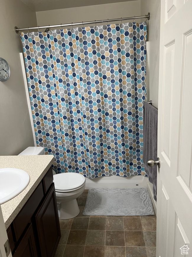 Full bath featuring a shower with curtain, toilet, and vanity | Image 22