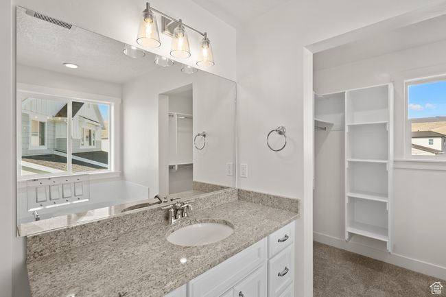 Bathroom featuring a walk in closet, vanity, and a textured ceiling | Image 21
